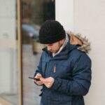 Joven pagando con tarjeta y móvil en la calle