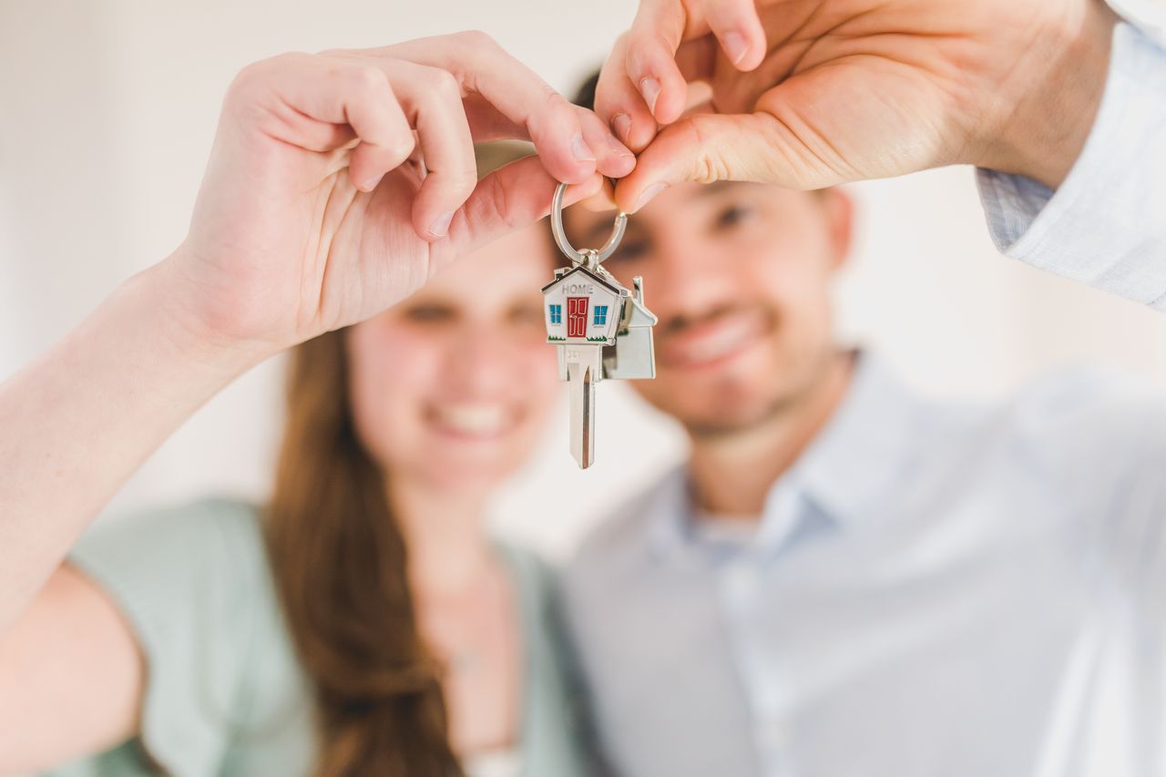 Pareja joven sosteniendo las llaves de su primera vivienda comprada con aval ICO en 2026