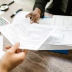 Persona entregando documentos para justificar una transferencia bancaria