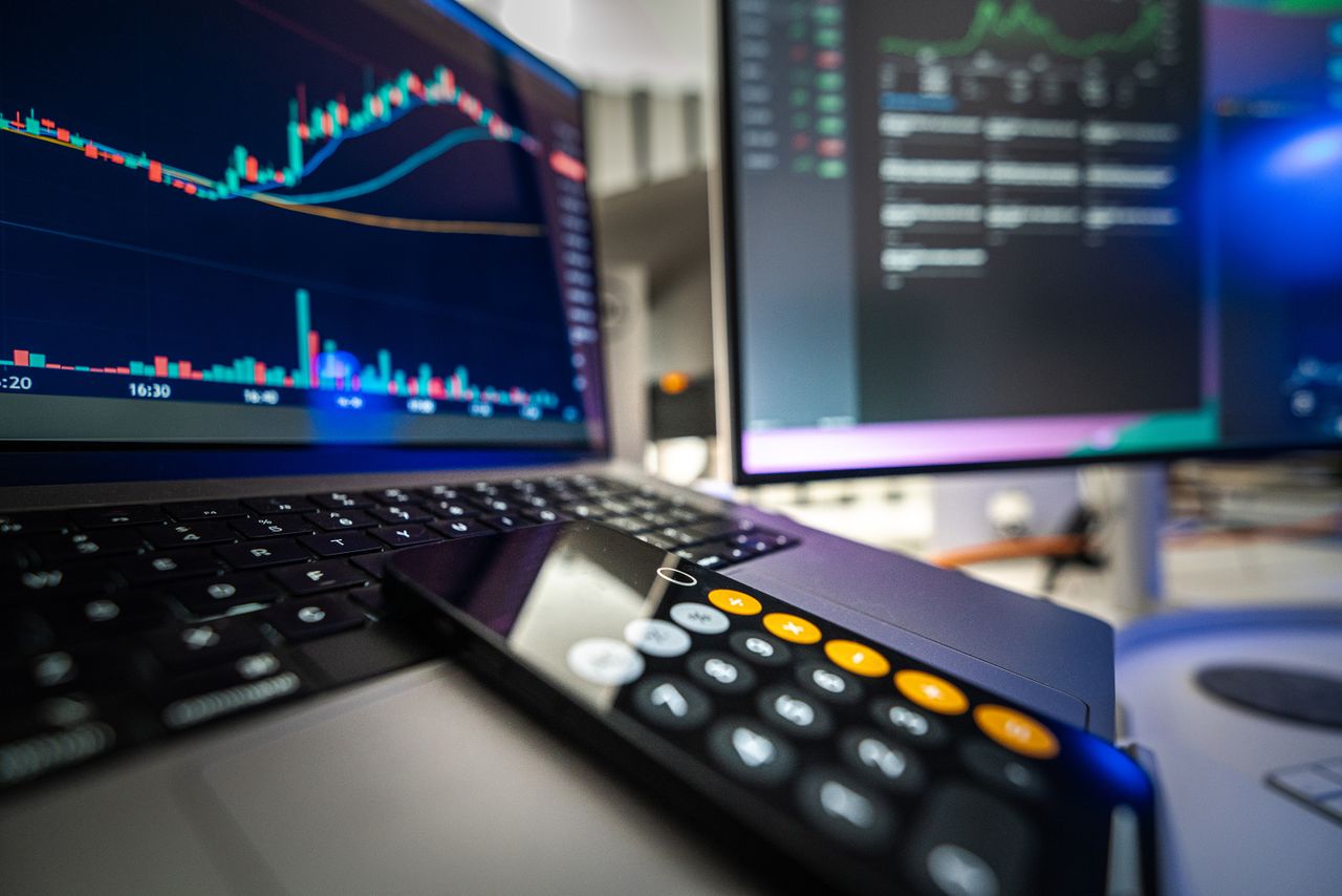 Persona revisando gráficos de pérdidas y ganancias financieras con una calculadora