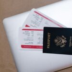 Pasaporte y billetes de avión sobre un portátil, documentos para contratar un seguro de viaje