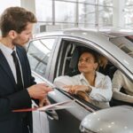Concesionario entregando las llaves de un coche nuevo a una clienta